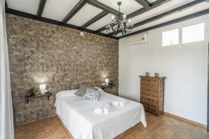 ein Schlafzimmer mit einem Bett und einer Ziegelwand in der Unterkunft Casa Rural La Perla in Paradas + 42 Fotos