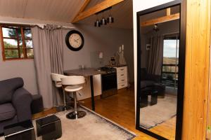 une cuisine et un salon avec une horloge au mur dans l'établissement Nkoyoyo Mountain Cabin, à Mbabane