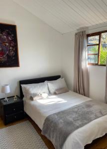 une chambre avec un grand lit et une fenêtre dans l'établissement Nkoyoyo Mountain Cabin, à Mbabane