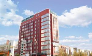 un grand bâtiment rouge dans une ville dans l'établissement GreenTree Inn HuaiAn Xiangyu Avenue International Mall Business Hotel, à Hexia