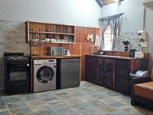 una cocina con lavadora y fregadero en Papagaai 2409, en Marloth Park