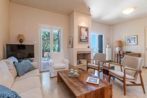 a living room with a couch and a table at Villa Oliva - Majestic Views in Andros