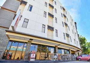 a large building with a restaurant in front of it at RedDoorz @ Express Inn Lapu Lapu in Gun-ob