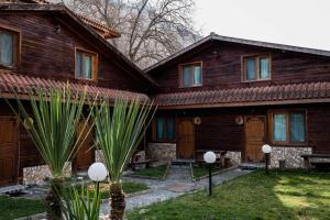 a wooden house with some palm trees in front of it at Стария Чинар in Melnik