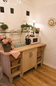 a kitchen with a microwave on a counter with flowers at Villa Tammsaare Deluxe Beach Apartment in Pärnu