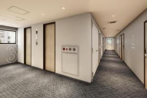 東京にあるHotel IL FIORE Kasai ANNEXの食器洗い機のあるオフィスビルの空っぽの廊下
