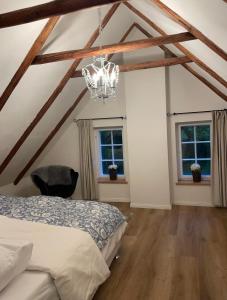 Un dormitorio con una cama y una lámpara de araña. en Reetdachhaus am See Ostfriesland, en Leezdorf