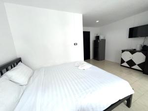 a bedroom with a white bed and a television at Patong Canal Villa R308 in Patong Beach