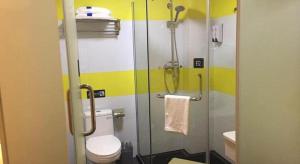 une salle de bain avec toilettes et douche en verre dans l'établissement 7 Days Inn Tongren Jiangkou Fanjing Mountain National Park, à T'ung-jen