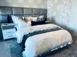 a bedroom with a large bed with a gray headboard at Zimbali Lakes Resort Ocean Club D24 in Ballito +17 photos