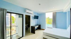 a blue room with a bed and a large window at Delighted Bangkok Hotel in Bangkok