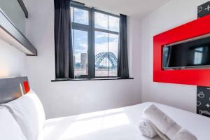 a bedroom with a bed with a tv and a window at easyHotel Newcastle in Newcastle upon Tyne