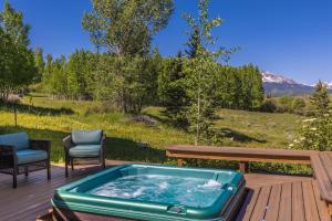 a hot tub on a deck with a table and chairs at Wapiti Lane home in Telluride