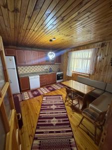 a kitchen with a wooden ceiling and a table at Zirve Apart in Uzungöl