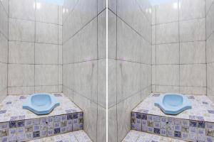 a bathroom with a blue toilet in a shower at Hotel O Gioba Kost Syariah in Grobogan