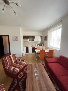 a living room with a red couch and a table at Apartman IRIS Podhajska in Podhájska