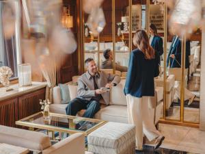 a woman standing in a store talking to a man at Fairmont Hotel Vier Jahreszeiten in Hamburg