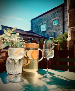 a table with two wine glasses on a table at Fox Cottage - Cosy Stay on Pateley High Street in Pateley Bridge