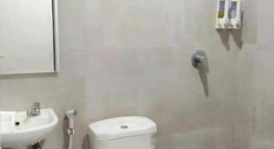a bathroom with a white toilet and a sink at Smart Budget Hotel in Stasiun Tawang +45 photos