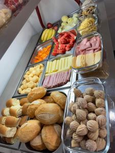 a display case filled with different types of food at HOTEL Pousada ACONCHEGO Promissão in Promissão