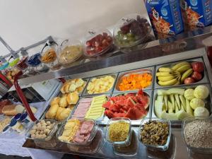 a buffet filled with different types of fruits and vegetables at HOTEL Pousada ACONCHEGO Promissão in Promissão +3 photos