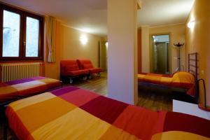 een kamer met 2 bedden en een stoel. bij Casa Mattia in Sorico