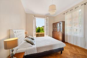Un dormitorio con una cama blanca y una ventana. en Villa Mi Rancho Vue mer - Wifi, Parking, Jardin, en Villefranche-sur-Mer