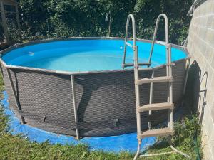 Una pequeña piscina con una escalera. en Maison 4 Chambres Normandie, en Clasville