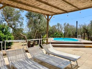 two chairs and a swimming pool in a yard at Villa Eos - Villa con Piscina Privata nel cuore del Parco Naturale di Andrano in Andrano