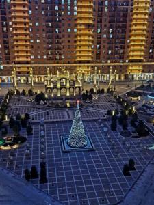 un arbre de Noël sur une place avec un bâtiment dans l'établissement Двухкомнатная квартира в ЖК Green Plaza, à Aktau