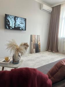 un salon avec une télévision au mur dans l'établissement Двухкомнатная квартира в ЖК Green Plaza, à Aktau