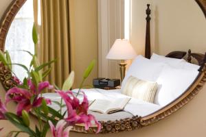 a mirror reflecting a bed with a book on it at The Halliburton in Halifax +11 photos
