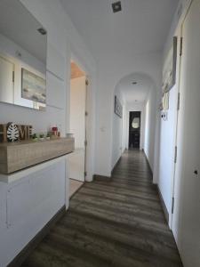 a hallway of a home with white walls and wooden floors at Acogedor Apartamento in Almerimar