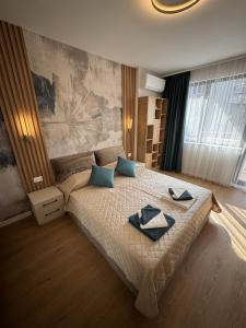 a bedroom with a large bed with two towels on it at Desire Luxury Apartment with private garage in Varna City
