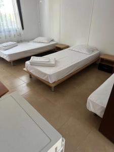 two beds in a room with two tables at Бунгала Виктори Victory Bungalows in Shkorpilovtsi