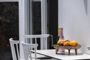 a table with a bowl of fruit and a bottle of champagne at Royal Garden Villas in Bali
