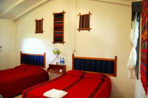 two beds in a room with red luggage at La Casa de Don David in El Remate