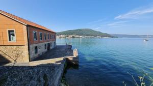 a building next to a large body of water at Apartamento con vistas al mar en Primera Línea. in Muros