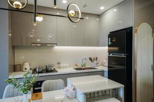 a kitchen with a black refrigerator and a table at Homestay Sài Gòn-Luxury Apartment in Long Bình