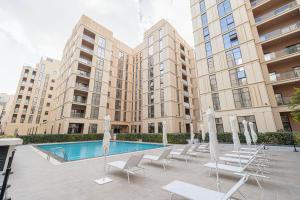 a group of chairs and a pool in front of a building at The Cloud 9 Penthouse by Blue Cloud Holidays in Sharjah Intl