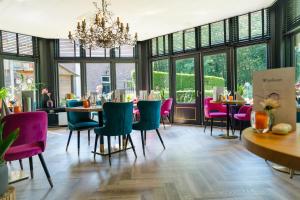 a dining room with tables and chairs and windows at Fletcher Boshotel De Lochemse Heuvels in Barchem
