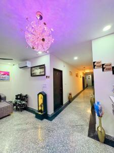 a living room with a purple ceiling and a chandelier at Hotel Kings Inn in Jaipur +5 photos