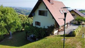 a white house with a red roof on a hill at Appartement Fernblick in Kitzeck im Sausal