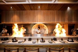 a group of chefs cooking in a kitchen with flames at Sini Vie Resort & Spa Seminyak by Ini Vie Hospitality in Seminyak +36 photos