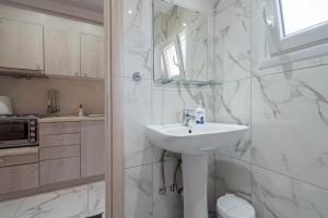a white bathroom with a sink and a mirror at Calua SeaView Rooms in Kriopigi +50 photos