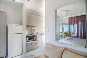 a kitchen with a white refrigerator and a mirror at Calua SeaView Rooms in Kriopigi