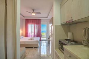 a room with a bedroom with a bed and a kitchen at Calua SeaView Rooms in Kriopigi