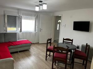 a living room with a table and a couch and a table and chairs at Vila FiDa in Gornja Toplica