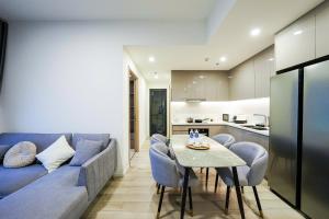 a living room with a blue couch and a table at Bống Homestay-Luxury Apartment-Vinhomes Grand Park in Long Bình