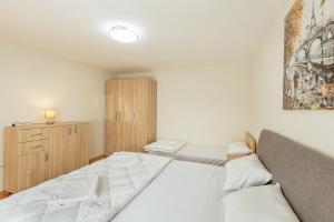 a bedroom with a bed and a wooden cabinet at Apartman Kovacevic Hn in Igalo +15 photos